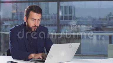 现代有吸引力的商人用笔记本电脑在办公桌上工作的画像